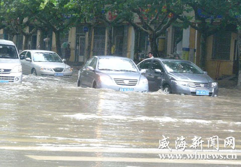 8月28日，文登市区降下暴雨，10时30分，在峰山路与龙山路交会处路面积水深约30厘米，已经没过汽车前保险杠。