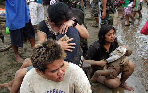12月17日,菲律宾南部棉兰老岛伊利甘市,两位妈妈抱着不幸夭折的孩子伤心欲绝。(图片来源于:凤凰网) 12月17日,菲律宾南部棉兰老岛伊利甘市,两位妈妈抱着不幸夭折的孩子伤心欲绝。(图片来源于:凤凰网)